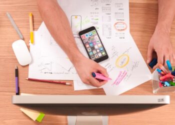 Manos con papeles y movil haciendo estrategia