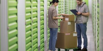 Trabajadores ticando paquetes en almacen