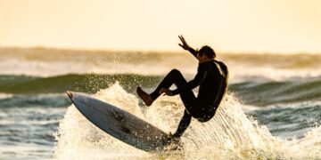 Persona practicando paddle surf en aguas tranquilas