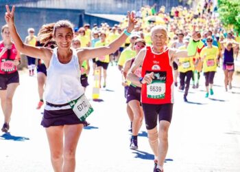 Corredores participando en una carrera popular urbana